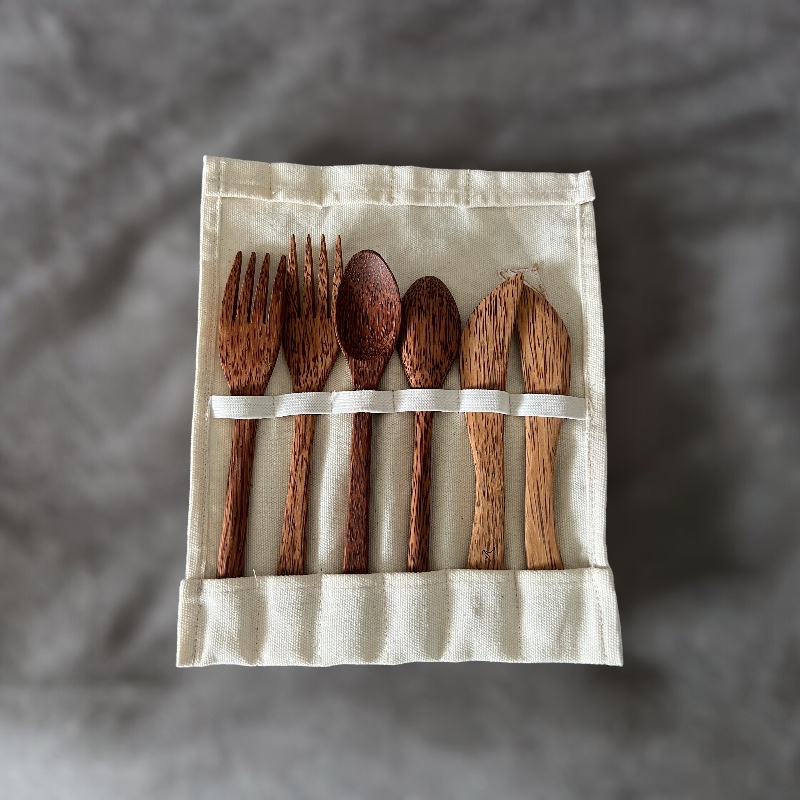 Duo de couverts dans sa pochette de transport à compartiments. Couverts en bois de cocotier avec une variation de couleurs