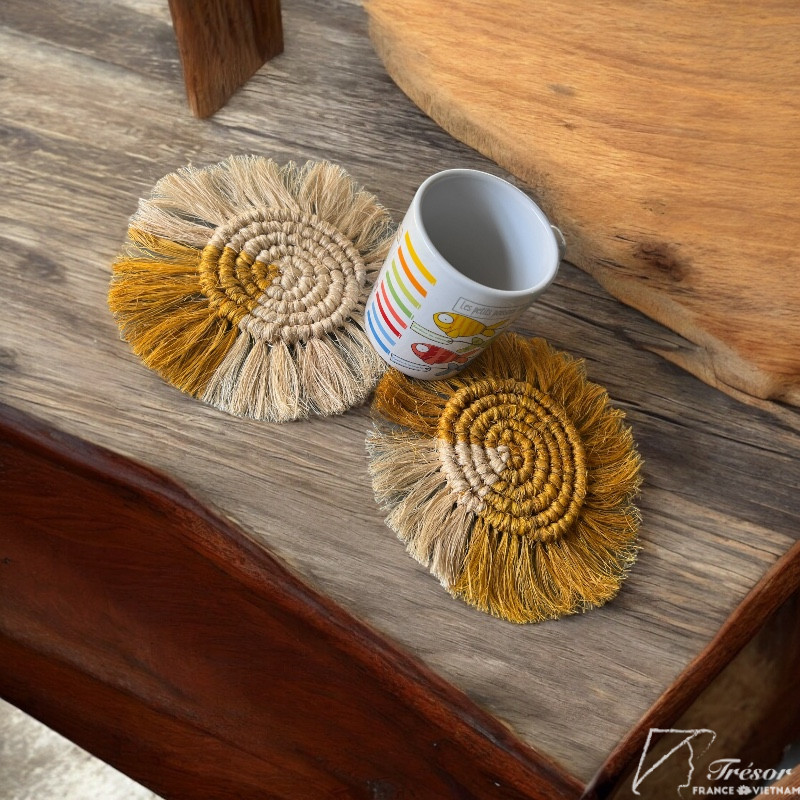 2 sous-verres en fibre de bananier couleur or et naturel avec tasse sur table en bois